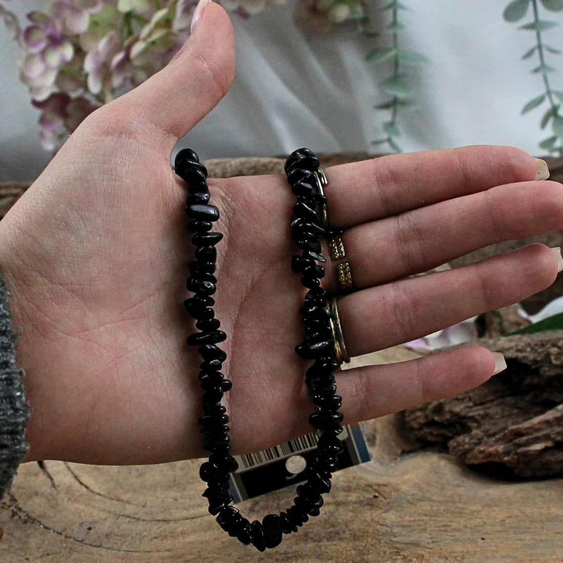 Svart turmalin halsband med glansiga pärlor på displaykort